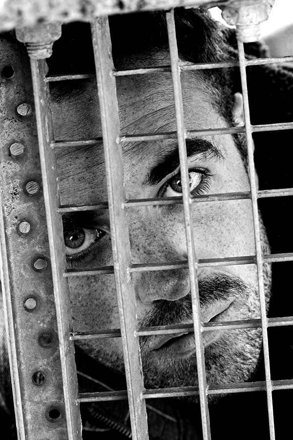 Ein Mann hinter einem Gitter